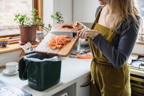 mid adult woman putting carrot shavings in compost bin - food stock pictures, royalty-free photos & images