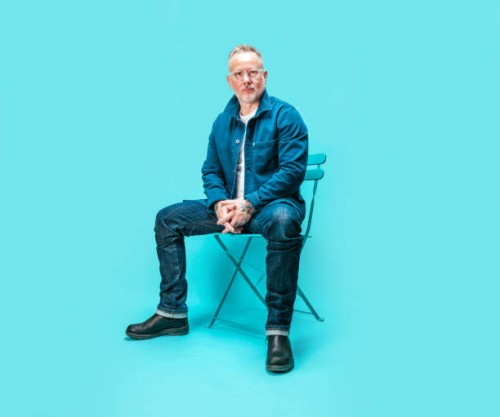 middle-aged man sitting on chair in studio - fashion stock pictures, royalty-free photos & images