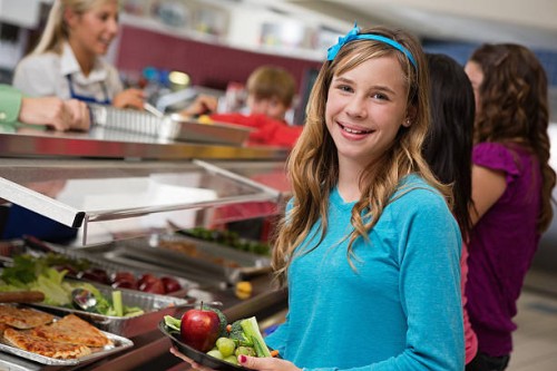 middle school girl with students in cafeteria lunch line - junk food stock pictures, royalty-free photos & images