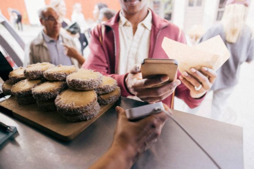 midsection of male customer paying through smart phone at food festival - junk food stock pictures, royalty-free photos & images