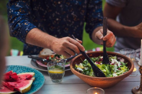 midsection of man mixing salad at table during garden party - garden decoration stock pictures, royalty-free photos & images