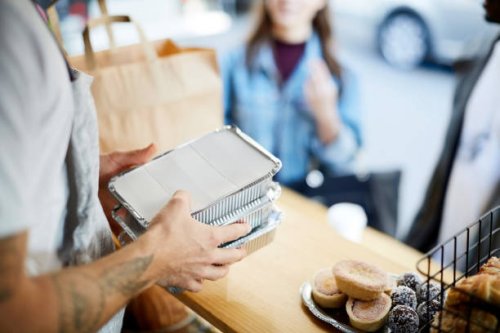 midsection of salesman holding takeaway packaged food for customers at concession stand - junk food stock pictures, royalty-free photos & images