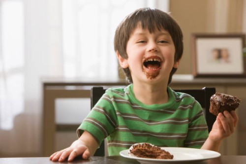 mixed race boy eating cupcake - junk food stock pictures, royalty-free photos & images