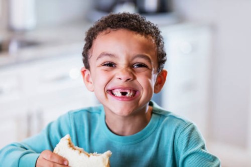 mixed race boy eating peanut butter sandwich - food stock pictures, royalty-free photos & images