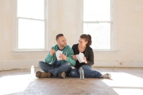 mixed race couple eating takeout on floor of new home - junk food stock pictures, royalty-free photos & images