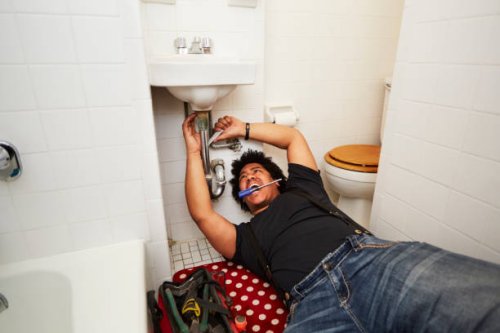 mixed race man fixing sink plumbing - home decoration stock pictures, royalty-free photos & images