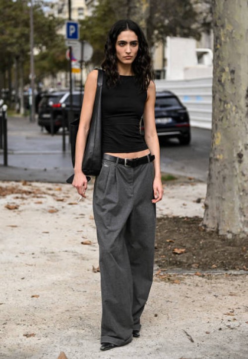 Model Capucine Clowes is seen wearing a black top, gray pants, black belt and black bag outside the Chanel show during the Womenswear Spring/Summer...