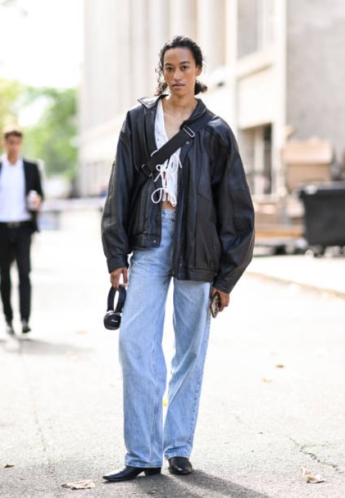 Model Ena Poppe is seen wearing a black jacket, white top, light blue jeans and black shoes outside the Miu Miu show during the Womenswear...