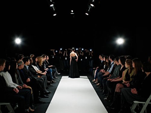 model in gown at end of catwalk posing - fashion week stock pictures, royalty-free photos & images