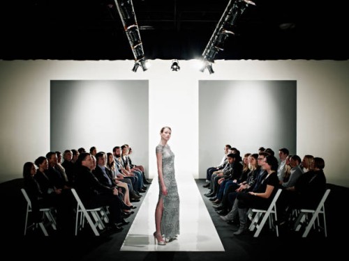 model in gown posing at end of catwalk - fashion week stock pictures, royalty-free photos & images