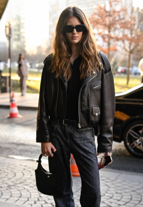 Model is seen wearing a biker jacket, black shirt, black jeans and black bag with black sunglasses outside the Stella McCartney show during the...