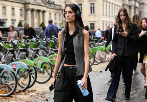 Model is seen wearing a black shirt, gray vest and black cargo pants outside the Chanel show during the Womenswear Spring/Summer 2024 as part of...