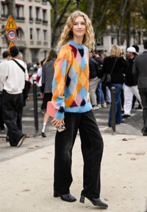 Model is seen wearing a blue and orange sweater and black jeans outside the Chanel show during the Womenswear Spring/Summer 2024 as part of Paris...