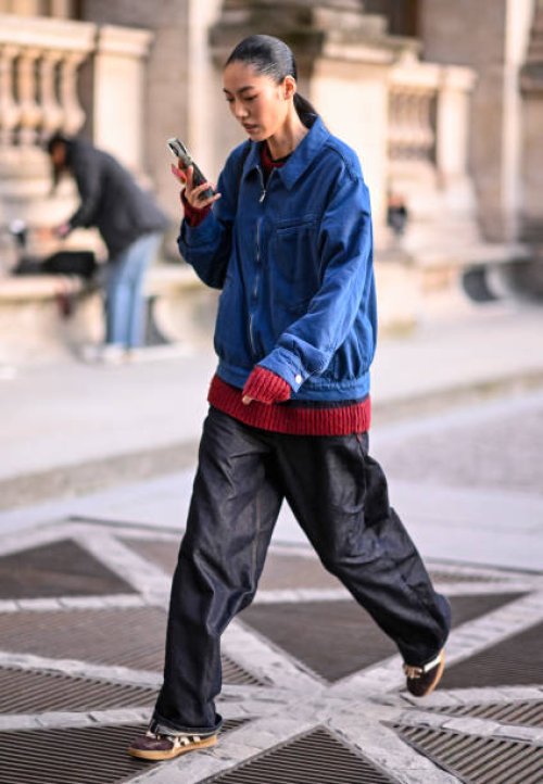 Model Song Ah Woo is seen wearing a blue jacket, red sweater, black pants and Adidas sneakers outside the Louis Vuitton show during Womenswear...