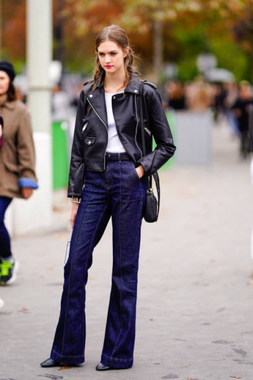 Model wears a black leather jacket, blue flared jeans pants, outside Chanel, during Paris Fashion Week Womenswear Spring/Summer 2019 on October 2,...
