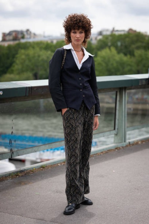 Model wears a blue blazer, printed pants, black loafers and black Chanel bag, outside Chanel, during the Haute Couture Fall/Winter 2023/2024 as part...