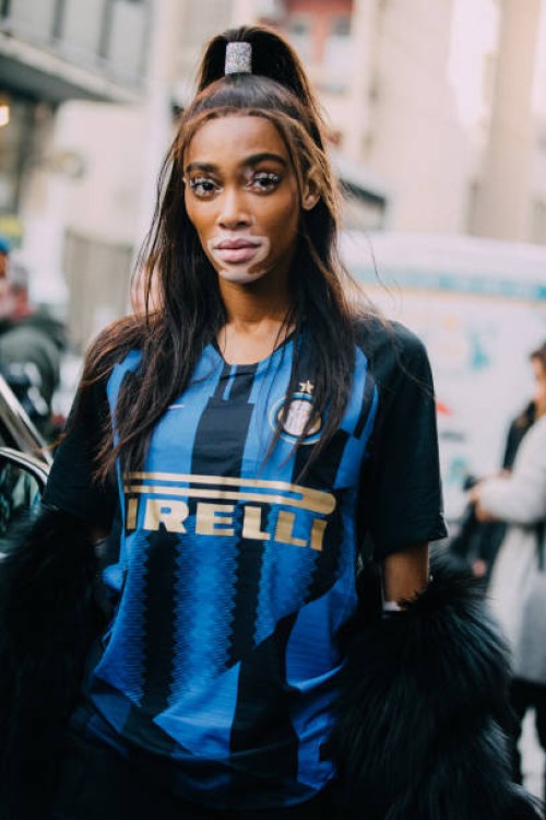 Model Winnie Harlow wears her hair in a high ponytail and wears a blue Pirelli soccer/football jersey after the Byblos show on Day 1 Milan Fashion...