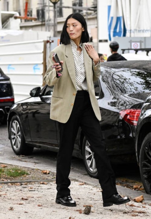 Model Yilan Hua is seen wearing a blazer, white and black button shirt, black pants and black shoes outside the Chanel show during the Womenswear...