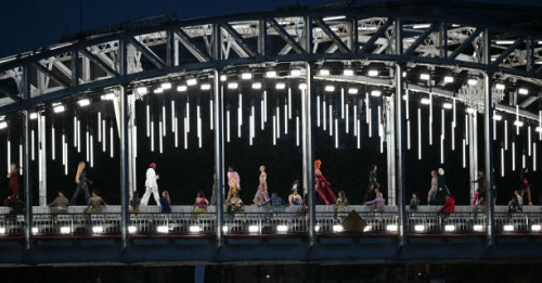 Models present creations while walking a catwalk erected along the Passerelle Debilly bridge along the Seine river during the opening ceremony of the...