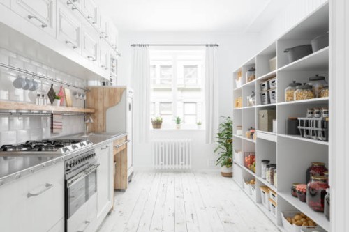 modern kitchen interior with white cabinets and organised pantry items, nonperishable food staples, preserved foods, healthy eating, fruits and vegetables in storage compartment. - food stock pictures, royalty-free photos & i