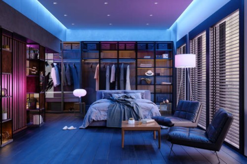 modern slaapkamerinterieur 's nachts met neonlicht. rommelig bed, kleding in kast, fauteuils en vloerlamp. - home decoration stockfoto's en -beelden