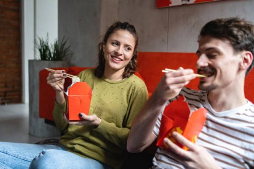 modern young couple enjoy the chinese take out food, while sitting on the floor - junk food stock pictures, royalty-free photos & images