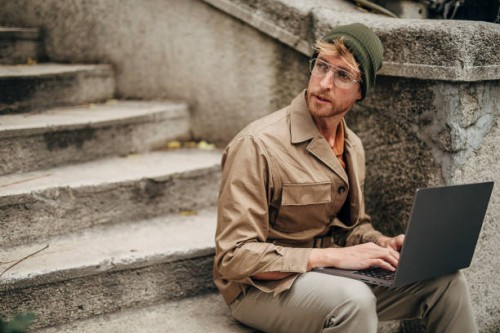 moderner mann mit laptop auf stufen in der stadt - fashion stock-fotos und bilder