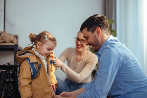 mom and dad dressing their daughter to go outdoors - junk food stock pictures, royalty-free photos & images