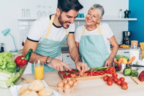 mother and adult son making salad together - food stock pictures, royalty-free photos & images