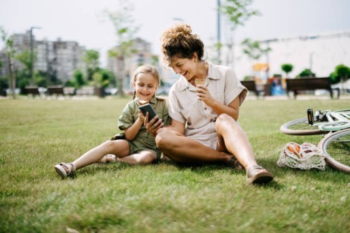 mother and daughter are sitting on the grass in the park - fashion stock pictures, royalty-free photos & images