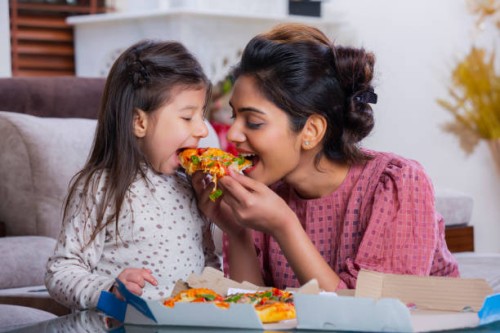 mother and daughter eating pizza stock photo - junk food stock pictures, royalty-free photos & images