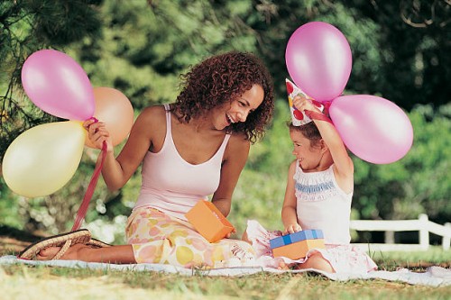 mother and daughter sitting in the garden face to face at a birthday party - garden decoration stock pictures, royalty-free photos & images