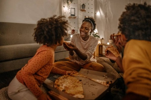mother feeding pizza to daughter - junk food stock pictures, royalty-free photos & images