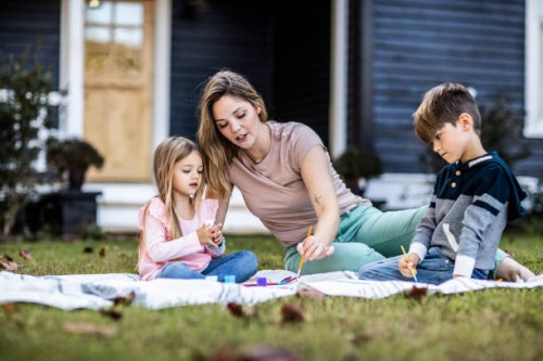 mother helping children paint in front yard of rural farmhouse - garden decoration photos et images de collection
