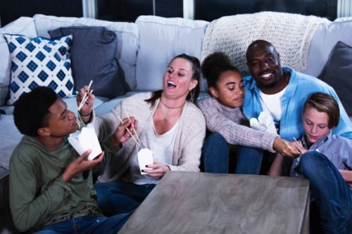 multi-ethnic blended family eating chinese take out food - junk food stock pictures, royalty-free photos & images