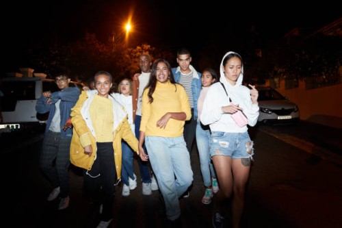 multi-ethnic friends walking on street in city at night - fashion stock pictures, royalty-free photos & images