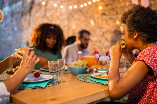 multi-generation family having dinner outdoors on an american national holiday - junk food stock pictures, royalty-free photos & images