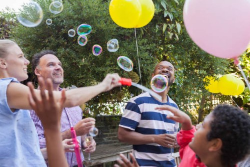 multi generation family party on garden patio playing with bubbles and balloons - garden decoration stock pictures, royalty-free photos & images