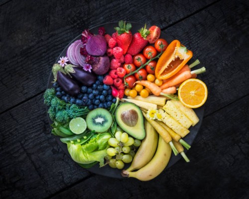 multicoloured fruit and vegetables in a black bowl on a burnt surface. - food stock pictures, royalty-free photos & images