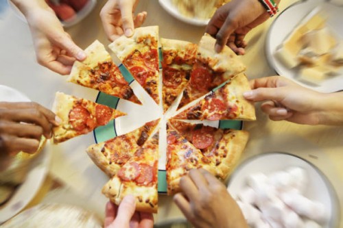 multiple hands reaching for pizza slices - junk food stock pictures, royalty-free photos & images