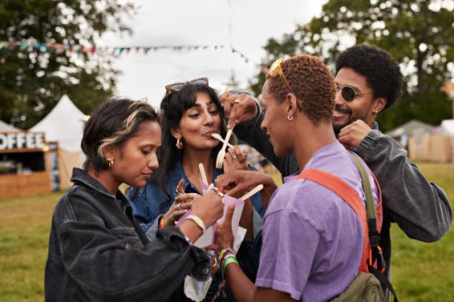 multiracial friends sharing dessert at concert - concert stock pictures, royalty-free photos & images