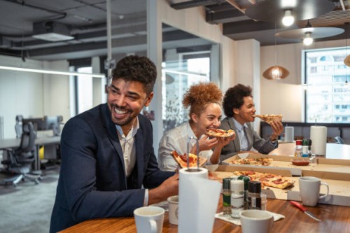 multiracial group of business people, eating a pizza for their lunch break at cafeteria - junk food stock pictures, royalty-free photos & images
