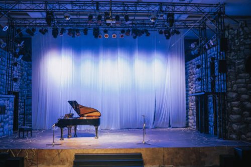 music stage theater with grand piano and white backdrop illuminated with stage light - concert stock pictures, royalty-free photos & images