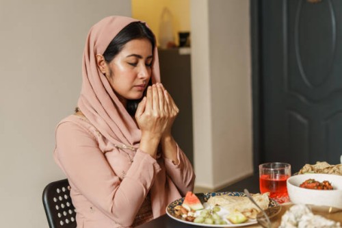 muslim woman reciting a prayer before iftar. - food fotografías e imágenes de stock