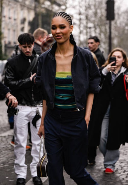 Nara Smith is seen wearing a black jacket, striped Miu Miu shirt, black pants and brown and white bag outside the Miu Miu show during the Womenswear...