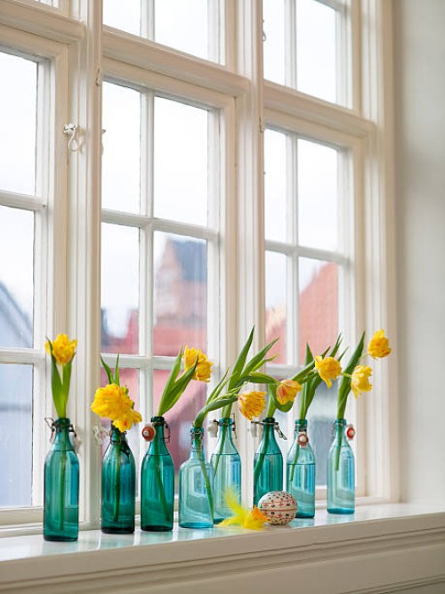 narcisses in bottles on window sill - home decoration stock pictures, royalty-free photos & images