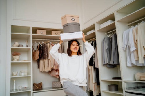new clothes purchase. smiling woman carrying clothes boxes on her head near walk in wardrobe - fashion stock pictures, royalty-free photos & images