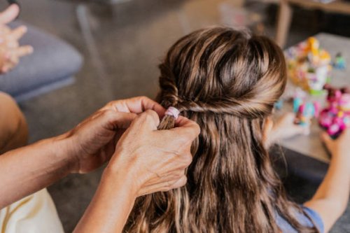 niña retorciéndose el pelo por su abuela en el salón de su casa - hairstyle fotografías e imágenes de stock