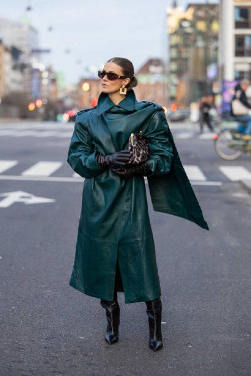 Nina Sandbech wears Celine sunglasses, black gloves, green leather coat, black boots, bag with leopard print, earrings on her way to Forza Collective...