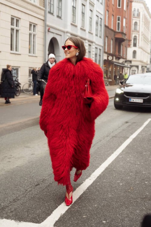 Nina Sandbech wears red tights, red shoes, red bag, red fur coat, and red sunglasses outside Aeron during the Copenhagen Fashion Week AW24 on January...